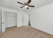 Thumbnail 13 of 26 - A room with a ceiling fan and carpeted floor at The Phoenix Apartments on 6th Avenue, Phoenix 85013