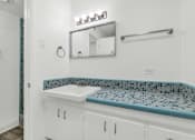 Thumbnail 15 of 26 - A bathroom with a white sink and a mirror above it at The Phoenix Apartments on 6th Avenue, Phoenix