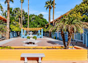 Thumbnail 19 of 26 - A bright yellow bench sits in front of a blue building with a palm tree at The Phoenix Apartments on 6th Avenue, Phoenix