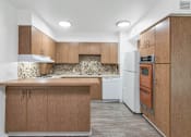 Thumbnail 2 of 26 - A kitchen with wooden cabinets and a white dishwasher at The Phoenix Apartments on 6th Avenue, Phoenix, AZ