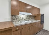 Thumbnail 4 of 26 - A kitchen with wooden cabinets and a tiled backsplash at The Phoenix Apartments on 6th Avenue, Arizona 85013