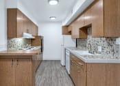 Thumbnail 5 of 26 - A kitchen with wooden cabinets and a tiled backsplash at The Phoenix Apartments on 6th Avenue, Phoenix, AZ