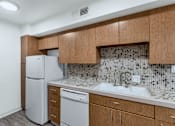 Thumbnail 6 of 26 - A kitchen with a white fridge and a white dishwasher at The Phoenix Apartments on 6th Avenue, Phoenix, Arizona