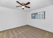 Thumbnail 9 of 26 - A room with a ceiling fan and carpeted floor at The Phoenix Apartments on 6th Avenue, Phoenix, AZ