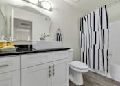 Thumbnail 11 of 36 - A white toilet sits next to a sink in a bathroom at Urban WalkApartments on 6th Avenue, Phoenix, AZ