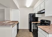 Thumbnail 13 of 36 - A kitchen with black appliances and white cabinets at Urban WalkApartments on 6th Avenue, Arizona
