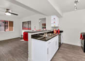 Thumbnail 2 of 36 - A kitchen with white cabinets and a black countertop at Urban WalkApartments on 6th Avenue, Phoenix 85016