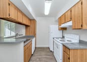 Thumbnail 20 of 36 - A kitchen with white appliances and wooden cabinets at Urban WalkApartments on 6th Avenue, Phoenix, Arizona