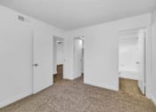 Thumbnail 23 of 36 - A white room with carpeted flooring and two doors at Urban WalkApartments on 6th Avenue, Phoenix 85016