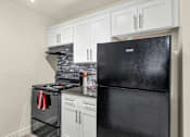 Thumbnail 3 of 36 - A black fridge sits next to a stove in a kitchen at Urban WalkApartments on 6th Avenue, Phoenix 85016