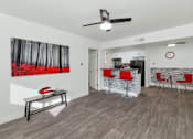 Thumbnail 6 of 36 - A room with a ceiling fan and a painting of a forest on the wall at Urban WalkApartments on 6th Avenue, Phoenix 85016