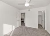 Thumbnail 8 of 36 - A room with a ceiling fan and carpeted floor at Urban WalkApartments on 6th Avenue, Phoenix