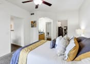 Thumbnail 15 of 29 - A bedroom with a bed covered in a white comforter and a ceiling fan.