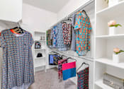 Thumbnail 17 of 29 - Clothes hanging on a rack in a room.
