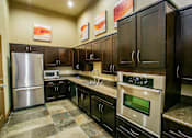 Thumbnail 10 of 27 - a kitchen with stainless steel appliances and wooden cabinets
