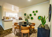 Thumbnail 9 of 25 - A kitchen with a table and chairs in the middle of the room.