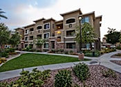 Thumbnail 25 of 27 - a large apartment building with a sidewalk and grass yard