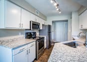 Thumbnail 4 of 24 - Albuquerque Apartment Kitchen with granite countertops and stainless steel appliances.