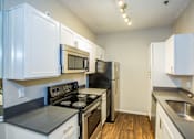 Thumbnail 11 of 29 - A kitchen with white cabinets and black appliances.