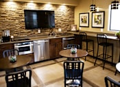 Thumbnail 15 of 24 - Clubhouse with Stools and Appliances at River Walk Apartments NM