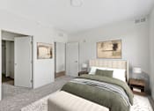 Thumbnail 5 of 6 - A bedroom with a large bed and a painting on the wall.