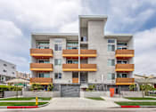 Thumbnail 1 of 10 - A modern apartment building with a mix of wood and concrete exterior.