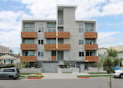 Thumbnail 4 of 10 - A modern apartment building with a mix of white and brown balconies.