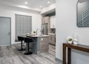 Thumbnail 16 of 26 - a kitchen with an island and a bar with two black stools at Lido Apartments - 4025 Grandview, Culver City, 90066