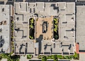 Thumbnail 3 of 8 - A courtyard surrounded by buildings with a fountain in the middle.