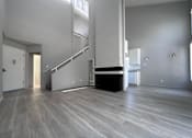 Thumbnail 5 of 7 - A spacious room with a staircase and a fireplace.