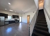 Thumbnail 9 of 9 - Open kitchen with staircase and dark flooring at Lido - 3630 Mentone Ave Apartments, Los Angeles, CA