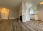 Thumbnail 2 of 7 - A room with wooden flooring and a white door.