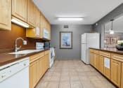 Thumbnail 14 of 21 - a kitchen with wooden cabinets and a sink and a refrigerator