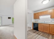Thumbnail 4 of 21 - a kitchen and living room with wood flooring and white walls