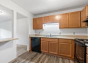 Thumbnail 3 of 21 - an empty kitchen with wooden cabinets and a stove and sink
