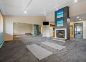 Thumbnail 17 of 21 - a large living room with a fireplace and yoga mats
