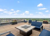Thumbnail 10 of 42 - an outdoor patio with blue chairs and a firepit with a view of the city