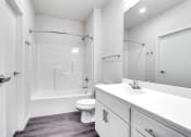 Thumbnail 38 of 44 - full bathroom with gray wood floors and white walls and finishes