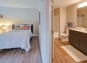Thumbnail 2 of 11 - a bedroom with a bed and a bathroom with a toilet