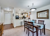 Thumbnail 23 of 23 - a dining area with a table and chairs and a kitchen in the background