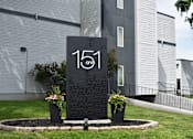 Thumbnail 20 of 20 - Monument sign at the entrance of  151 on 8 surrounded by landscaping.