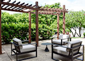 Thumbnail 6 of 27 - Two chairs and a table are under a wooden pergola.