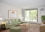 Thumbnail 1 of 20 - A living room with a green couch, a coffee table, and a painting on the wall.