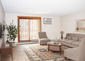 Thumbnail 28 of 29 - A living room with a couch, chair, and a rug.