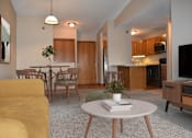 Thumbnail 3 of 32 - A living room with a yellow couch and a white coffee table.