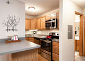 Thumbnail 8 of 32 - Kitchen with light brown panel wood cupboards and stainless steel appliances