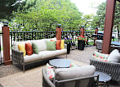 Thumbnail 26 of 29 - A patio with a couch, chairs, and a table.