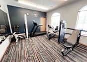 Thumbnail 7 of 13 - A gym with treadmills, exercise bikes, and weight machines.