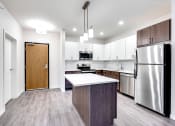 Thumbnail 32 of 44 - brightly lit apartment entryway and kitchen with island