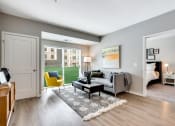 Thumbnail 2 of 31 - a living room with a gray couch and yellow chair and a sliding glass door leading to a